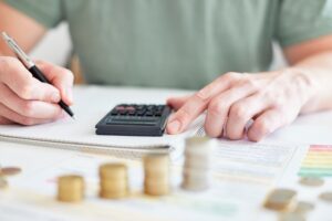 Mann am Schreibtisch macht Berechnungen