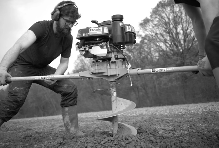Olef Koch der Uni Hohenheim bohrt ein Loch um einen Baum zu pflanzen